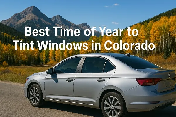 Silver sedan with tinted windows parked along a Colorado road in front of golden aspen trees and mountains during autumn.